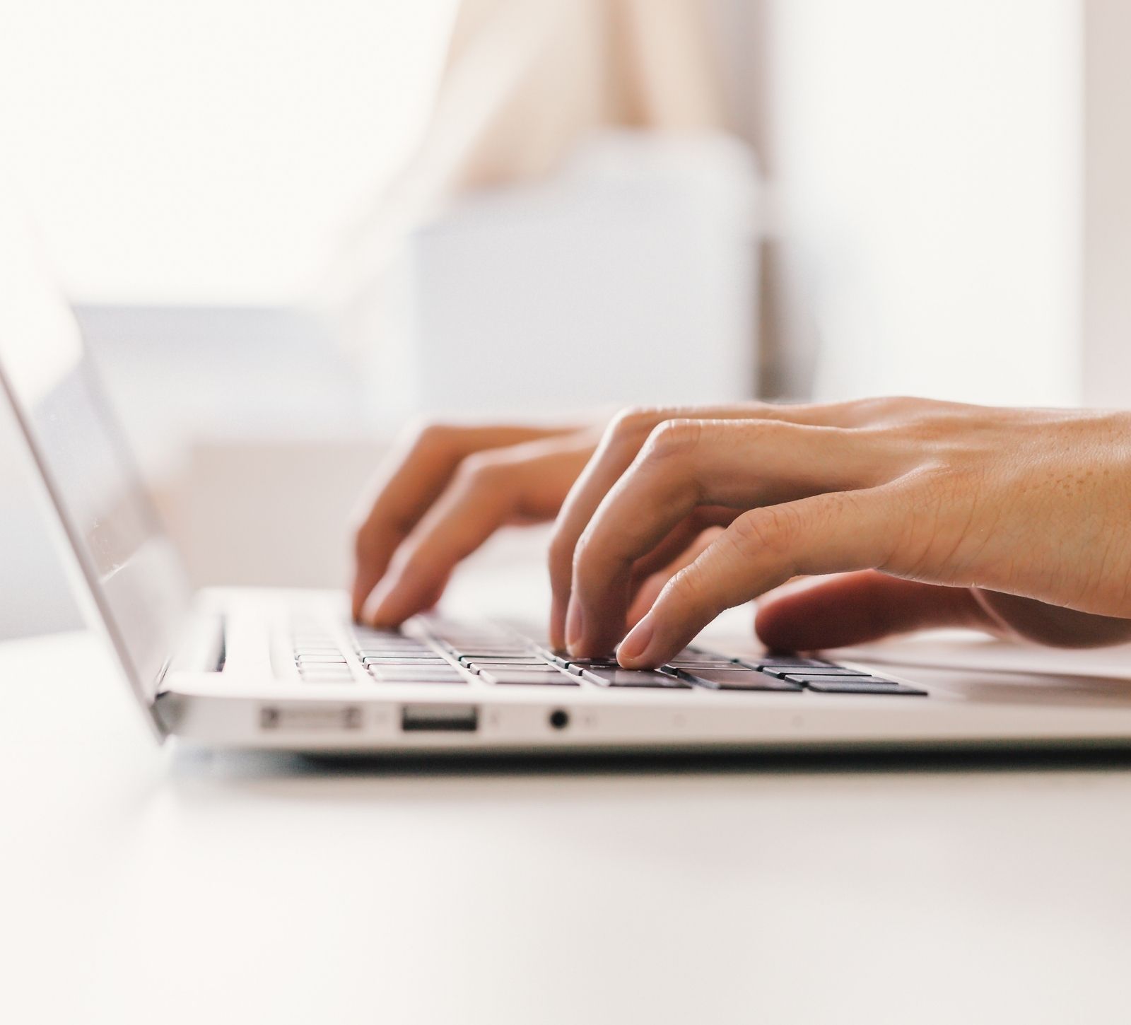 Female entrepreneur typing on keyboard and using Flodesk - an email management platform.