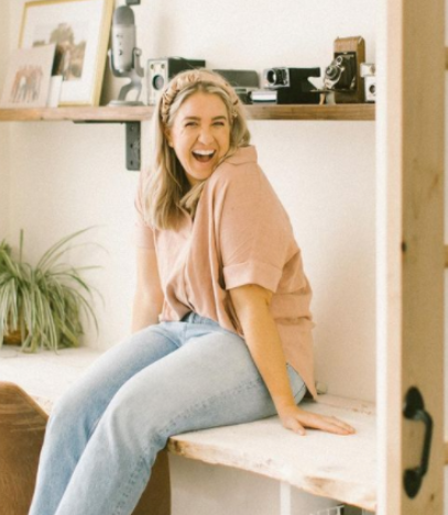 Kitchen Table CEOs - - Blog - Press - media - The World Needs More Jenna Kutchers - image of Jenna Kutcher, Host of Goal Digger Podcast on a countertop smiling.